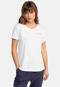 Camiseta blanca de algodón con cuello redondo, mangas cortas enrolladas y un pequeño logotipo bordado de Roxy en coral en el pecho.