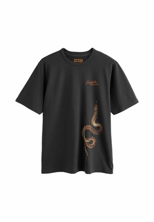 Must lühikeste varrukatega T-särk, mille alumisel paremal küljel on keerutatud pruun madu ning rinnal on väike pruun tekst "Shingaku Studios".