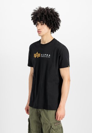 Μαύρο βαμβακερό t-shirt με λευκό και χρυσό λογότυπο "Alpha Industries". Κλασικός σχεδιασμός με στρογγυλή λαιμόκοψη, κοντά μανίκια και άνετη εφαρμογή.