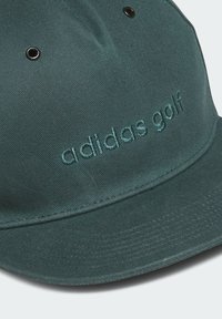 Gorra verde fabricada con tela texturizada, con visera curva, diseño de seis paneles y logo bordado de "adidas golf" en hilo del mismo color.