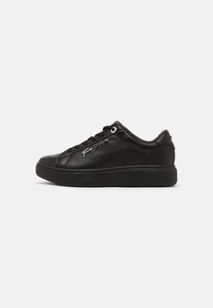 Sort lavtopet lædersneaker med sort sål, snørebånd og sølv signaturlogo på siden mod en ensformet hvid baggrund.