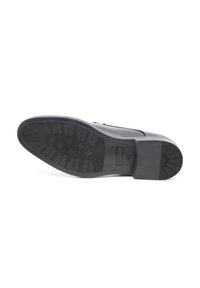 Scarpa in pelle nera con tomaia liscia e suola in gomma testurizzata, caratterizzata da un battistrada pattern e un marchio discreto sul lato.