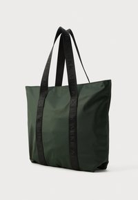 Bolsa tote verde fabricada en nylon, con asas de tela negras y branding en relieve, forma rectangular y una textura suave.