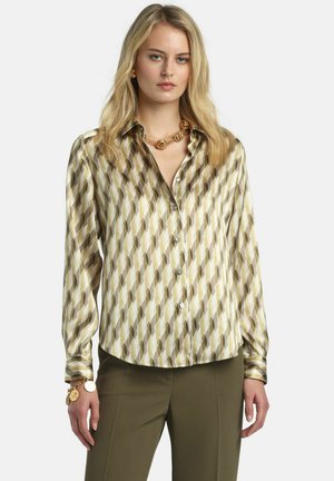 Blouse à manches longues en tissu soyeux présentant un motif géométrique dans des tons verts doux, jaunes et bruns, avec un devant boutonné et un ourlet arrondi.