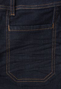 Jean en denim foncé avec une poche arrière. Présente des coutures doré-brun contrastantes et une finition de tissu lisse et légèrement texturée.