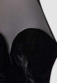 Czarny aksamitny top z dekoltem w kształcie serca, z przezroczystą czarną siateczką na ramionach i teksturowanym materiałem na powierzchni.