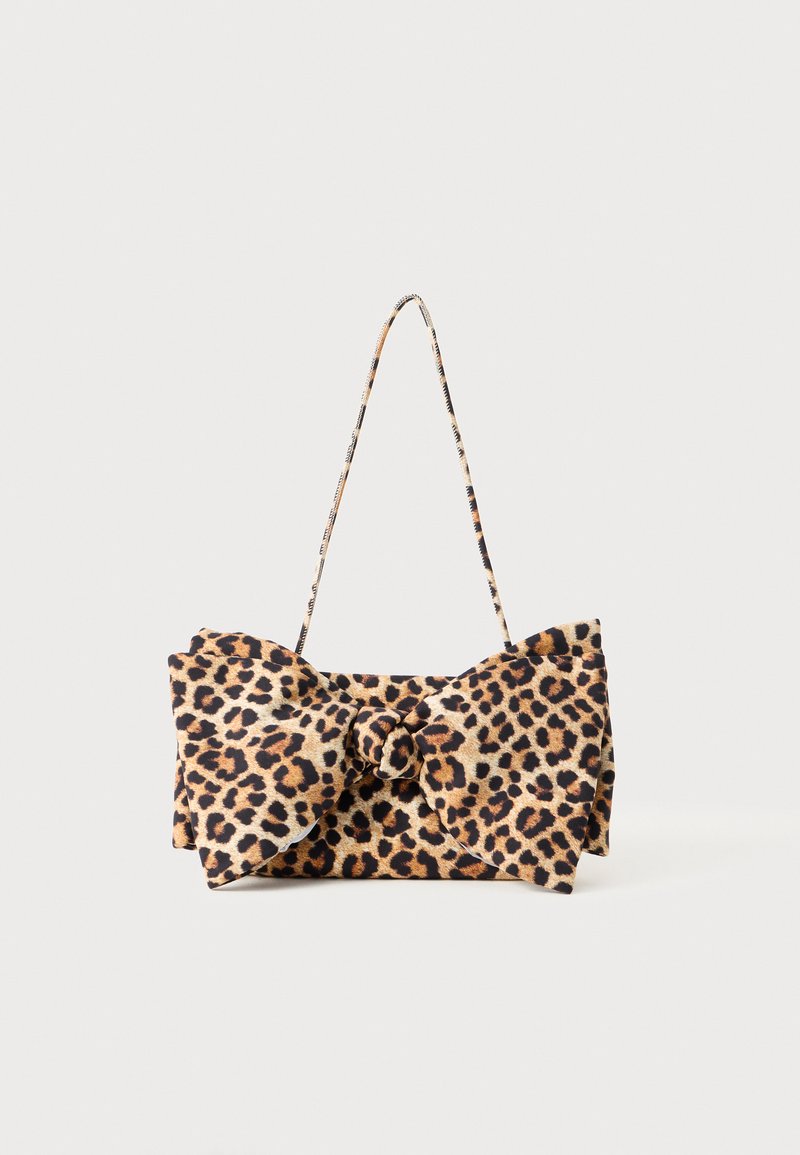 Lauvas raksta rokassoma ar lielu loku detaļu priekšpusē un platu plecu siksnu.