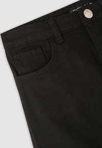 Czarne dżinsy wykonane z denimu, charakteryzujące się klasycznym pięciokieszeniowym designem, wytrzymałym przeszyciem i metalowym zapięciem na fakturowanym materiale.