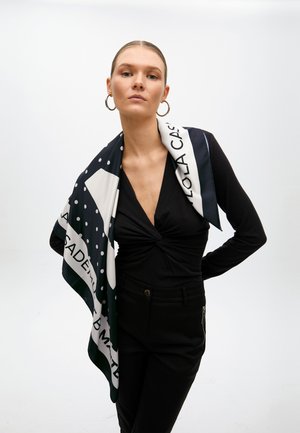 Silk scarf featuring a navy background with white polka dots and geometric patterns. The product has smooth texture and elegant drape.