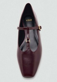 Zapato Mary Jane de cuero burdeos con punta cuadrada, una correa delgada con hebilla en tono dorado y un acabado suave.