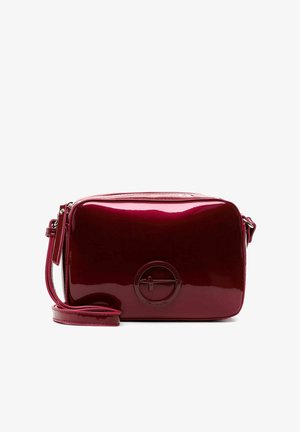 Glänzende, dunkelrote, rechteckige Umhängetasche mit verstellbarem Riemen und rundem, geprägtem Logo in der Mitte vorne.