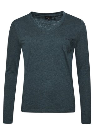 Ciemnoturkusowa koszula z długim rękawem i dekoltem w kształcie litery V, z małą kieszonką na piersi i delikatnie teksturowaną tkaniną, metka widoczna wewnątrz kołnierza.