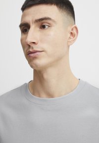 Lichtgrijs crewneck t-shirt van zachte katoen. Heeft een soepele textuur en een klassieke snit, met korte mouwen en een eenvoudig ontwerp.