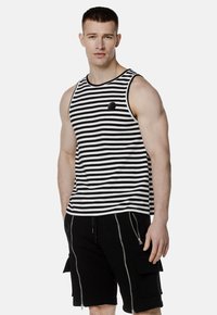 Czarna i biała paskowana koszulka na ramiączkach z okrągłym dekoltem i małym logotypem, w połączeniu z czarnymi szortami cargo z zamkami.