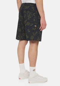 Pantaloni corti da uomo in tessuto blu navy con motivi astratti verdi e blu. Presentano una vita elasticizzata e tasche laterali.