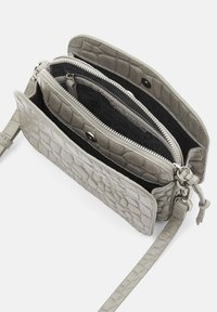 Borsa a tracolla in pelle grigia con texture, dotata di due scomparti con zip e chiusura a scatto magnetico, presenta una tracolla sottile e regolabile.