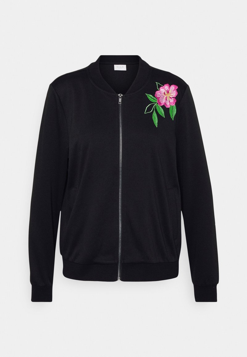 Veste noire zippée avec col et poignets côtelés, présentant une broderie de fleur rose et de feuille verte sur la poitrine côté supérieur gauche.