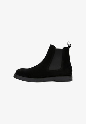Zwarte suede Chelsea boot met elastische zijpanelen en een lussenhandvat. Voorzien van een platte zool met een gestructureerde afwerking voor extra grip.