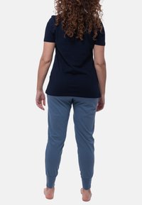 Marinblå kortärmad t-shirt i kombination med blå joggerbyxor. Mjuk tyg, åtsittande design, elastiska mudd på byxorna och inga synliga mönster eller logotyper.