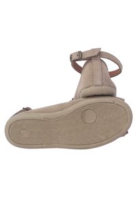 Sandalias de ante beige con una sola correa en el tobillo, suela de goma texturizada y punta redondeada. Presenta costuras y un tacón moldeado para mayor soporte.