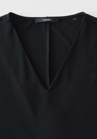 Zwarte blouse met een V-halsontwerp, gemaakt van een gladde stof. Bevat een centrale naad aan de achterkant en een label met de merknaam "someday."
