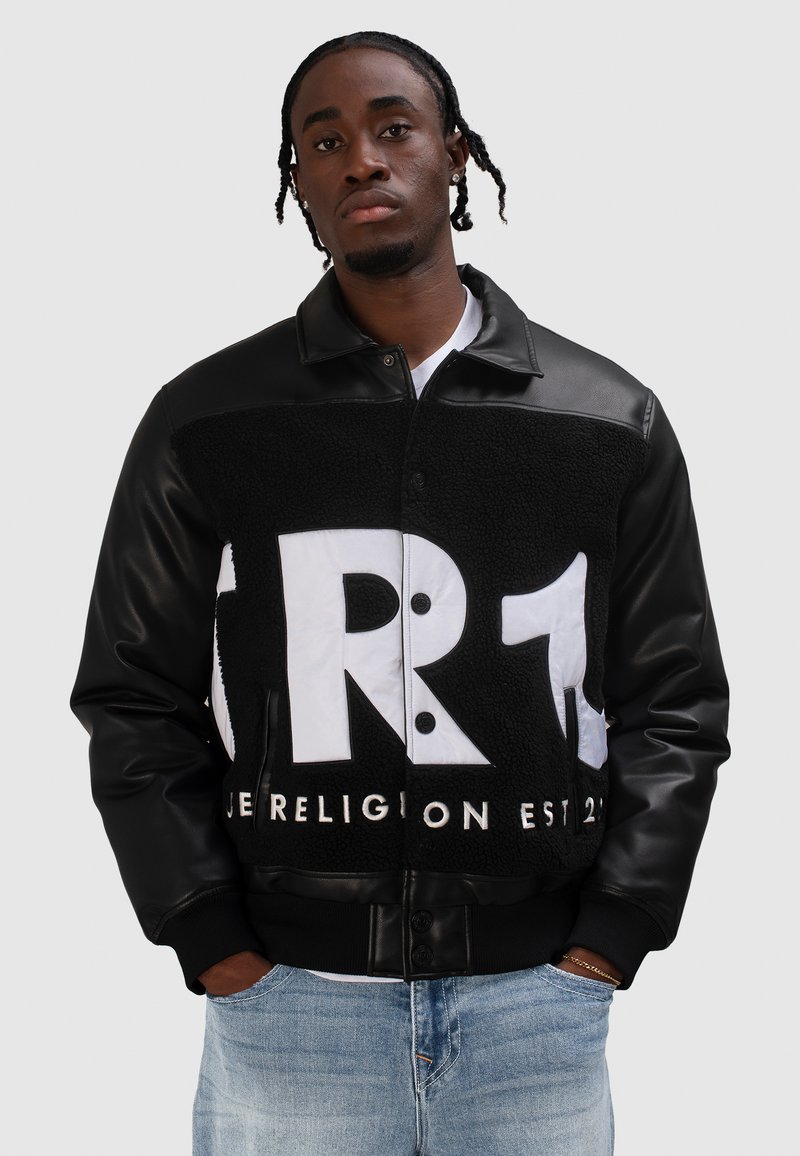 Czarna skórzana kurtka z polaru z białym graficznym logo; posiada zatrzaski z przodu, ściągacze na mankietach i kontrastującą fakturę.