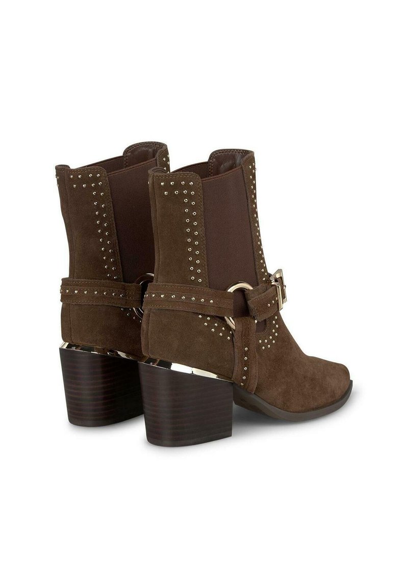 Botas de tobillo de ante marrón con tacón sólido, paneles elásticos y acentos con tachuelas. Cuenta con un cinturón decorativo con una hebilla de metal.