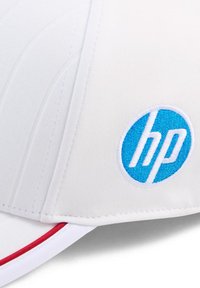 Biała czapka baseballowa o strukturalnym designie, z niebieskim haftowanym logo HP na okrągłej naszywce oraz czerwonym akcentem na daszku.