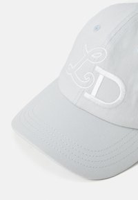 Lys grå baseballcaps med hvit brodert "LD"-logo foran, som viser den buede skjermen og stoffets tekstur.