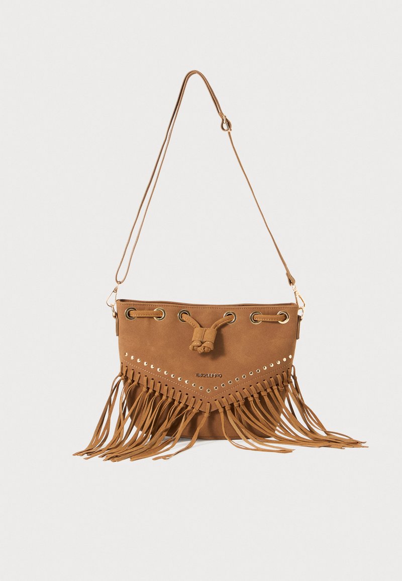 Borsa a secchiello in suede marrone con dettagli in frange, borchie in tono oro e chiusura con cordoncino. Dotata di una sola tracolla regolabile.