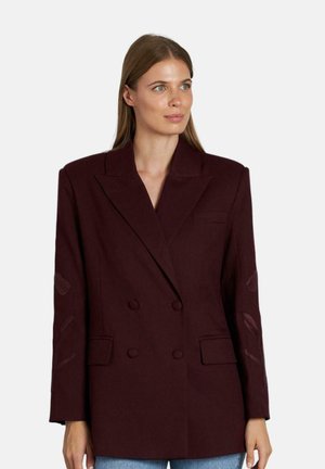 Blazer bordeaux doppiopetto con un design strutturato, dettagli di cuciture decorative sulle maniche e colletto a pastrano.
