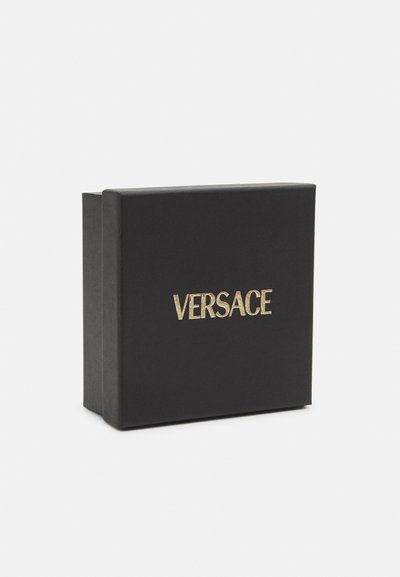 Scatola di cartone nera con una finitura testurizzata, decorata con il logo dorato "VERSACE" sulla parte anteriore. Forma rettangolare semplice con coperchio a cerniera.