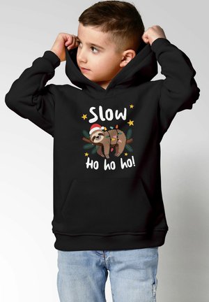 Schwarzer Hoodie mit einer Grafik eines Faultiers mit Weihnachtsmütze, Lichterketten und dem Text „Slow ho ho ho!“ auf der Vorderseite.