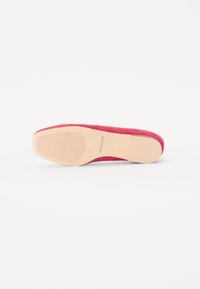 Rosa semskete sko med flat såle, har en teksturert gummiyttersåle og en glatt, avrundet tådesign. Stemplert merkenavn på sålen.