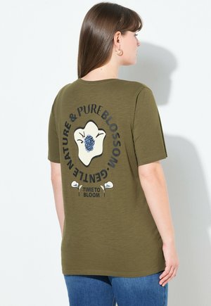 Olive zelené bavlněné tričko s krátkými rukávy, které má na zádech květinový grafický vzor s textem. Měkká textura, pohodlný střih a kulatý výstřih.