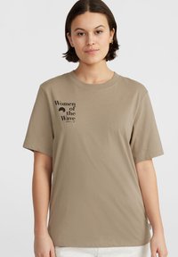 Beige puuvillane T-särk lühikeste varrukate ja ümmarguse kaelusega. Omab musta trükist "Women of the Wave" ja väikest logo.