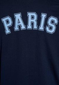 Tissu bleu marine avec le mot "PARIS" imprimé en grandes lettres majuscules bleu clair au centre.