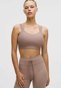 Brassière de sport côtelée marron clair avec larges bretelles et encolure dégagée, associée à un legging taille haute assorti doté d'un cordon de serrage.