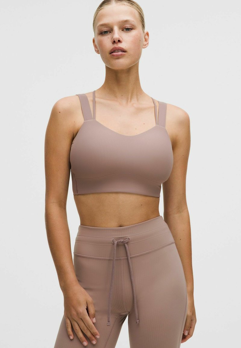 Brassière de sport côtelée marron clair avec larges bretelles et encolure dégagée, associée à un legging taille haute assorti doté d'un cordon de serrage.