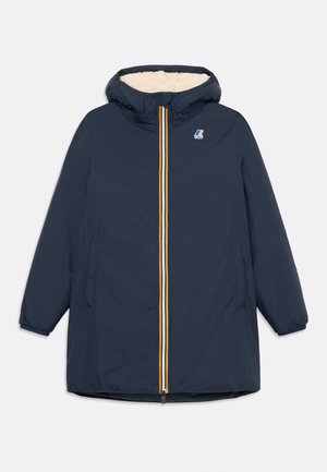 Parka blu navy con cappuccio, foderato in pile crema, chiusura con zip frontale con strisce gialle e rosse, e tasche laterali. Presenta maniche lunghe.