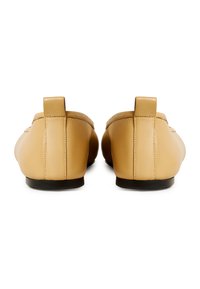 Scarpe slip-on in pelle marrone chiaro con punta arrotondata, cuciture minime e tacco basso, dotate di una distintiva linguetta sul retro per un facile indossamento.