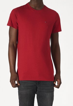 Červené bavlněné tričko s klasickým kulatým výstřihem, krátkými rukávy a malým brandovým logem na hrudi. Mírně přiléhavý střih.