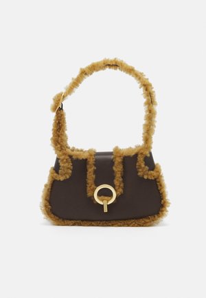 Brązowa torebka z puszystymi, karmelowymi akcentami wzdłuż brzegów i uchwytu; z okrąłym złotym detalem na przodzie.