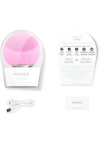 Rosa silikonansiktsrengöringsapparat med texturerad yta, USB-laddningskabel, äkthetskort och instruktionskort presenterad på en vit bakgrund.