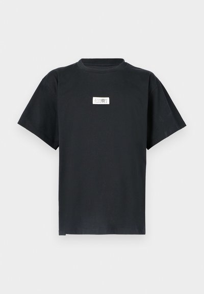 Μαύρο βαμβακερό t-shirt με στρογγυλή λαιμόκοψη, κοντά μανίκια και ένα ορθογώνιο λευκό ετικέτα στο στήθος που εμφανίζει κείμενο και αριθμούς.