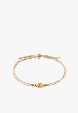 Regulowana bransoletka ze złotego plecionego sznurka z centralnym charmem w kształcie czterolistnej koniczyny oraz złotymi koralikami na białym tle.