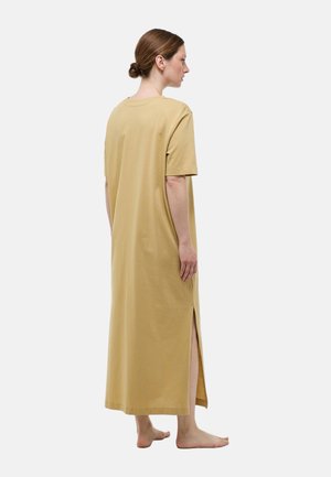 Robe maxi en coton doux couleur moutarde. Manches courtes, col rond, fentes latérales pour le mouvement et coupe décontractée.
