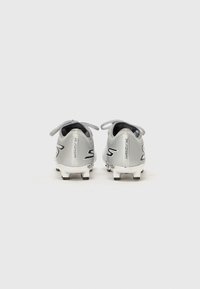 Chaussures de football en argent avec une finition texturée, dotées d'accents et de lacets noirs. Des crampons sur la semelle extérieure pour une meilleure traction.