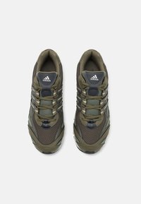 Olivgrön träningsskor med andningsbart nät och syntetiska överdrag, med en svart och blå design, texturerade snörningar och en vadderad krage.