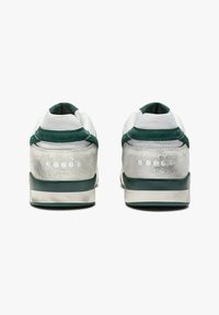 Sneakers da donna con una tomaia in rete bianca e dettagli verde, un tallone in suede e una suola spessa. Logo impresso sul retro.